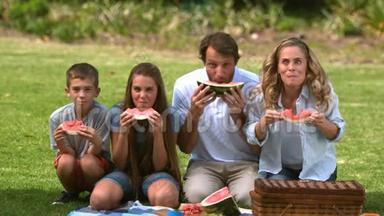 快乐的一家人在野餐时吃西瓜
